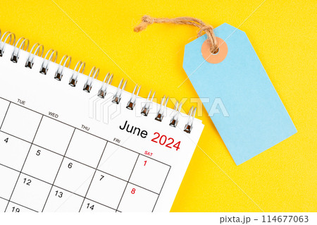 June 2024 desk calendar with blank price tag on yellow. 114677063