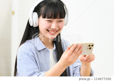 高校生　女の子　ヘッドフォン　スマホ 114677200