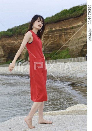 屛風ヶ浦を背景に赤いワンピースを着た女性 114679390