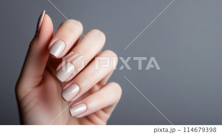 Close-up of female hand with beautifully manicured nails, displaying on gray backdrop, highlighting artistry and luxury of professional nail care Close-up of female hand with beautifully manicured nails, displaying on gray backdrop, highlighting artistry and luxury of professional nail care 114679398