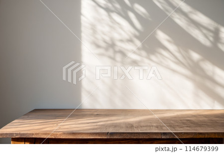 Product placement. wooden table and wall with tree shadow pattern, aesthetic contrast, items display, polished wood tabletop 114679399