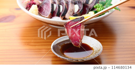 鰹のたたきをポン酢につける ( 南紀勝浦港 ) 114680134