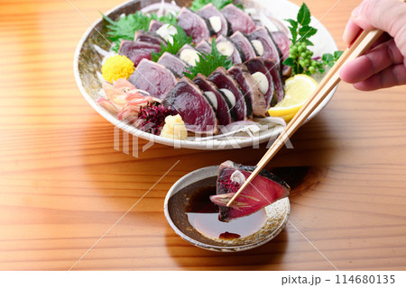 鰹のたたきをポン酢につける ( 南紀勝浦港 ) 114680135