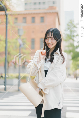 バッグの中をガサゴソしている街を歩く若い女性 バッグの中をガサゴソしている街を歩く若い女性 114680502