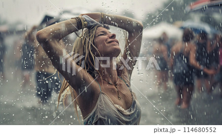 summer music festival-goer dancing in the rain at a summer music festival 114680552