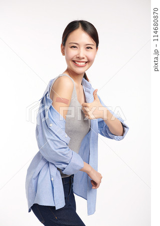 young asian women smiling after getting a vaccine, holding down her shirt sleeve and showing her arm with bandage after receiving vaccination on white background, young asian women smiling after getting a vaccine, holding down her shirt sleeve and showing her arm with bandage after receiving vaccination on white background, 114680870