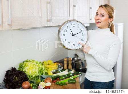 Portrait of positive woman holding clocks 114681874