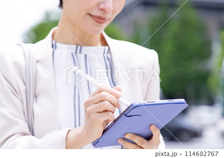 ビジネス　タブレットに書き込みをしている女性の手元 114682767