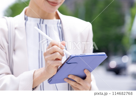 ビジネス　タブレットに書き込みをしている女性の手元 114682768