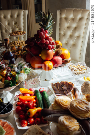 A large variety of fruits and vegetables on the table for guests 114683679