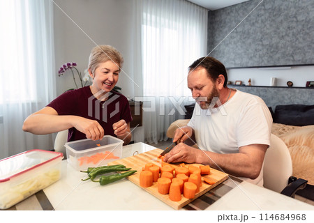 Mature russian husband and wife cooking pilaf together in the kitchen at home 114684968