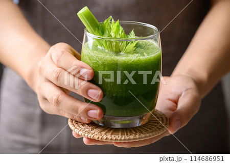 Celery green juice in glass holding by hand, Healthy drink for detox Celery green juice in glass holding by hand, Healthy drink for detox 114686951