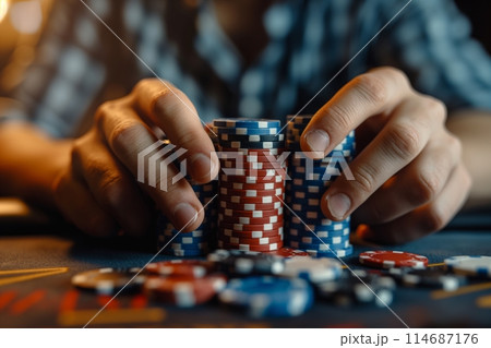 Hands organize blue and red poker chips in a tense casino setting 114687176