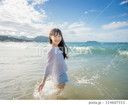 リゾート ビーチを歩く若い女性 リゾート ビーチを歩く若い女性 114687553