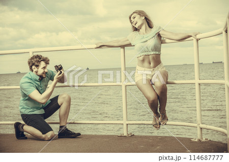 Young couple in love is taking photos on sea pier. 114687777