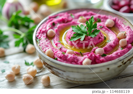 Beetroot hummus with olive oil and parsley in a decorative bowl 114688119