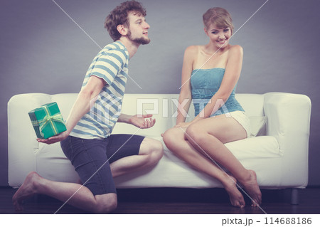 Young man giving woman gift box Young man giving woman gift box 114688186