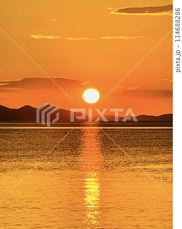 離島の海に浮かぶ夕日 114688286