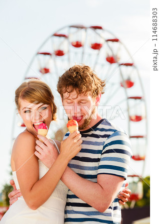 young couple eating ice cream outdoor 114688303