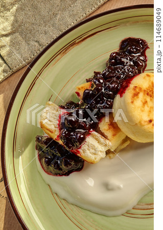 Homemade sweet syrniki ith creamy cheese cream and berries 114689049