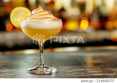Lemon Meringue cocktail topped with a creamy swirl and lemon slice on a bar counter 114689275