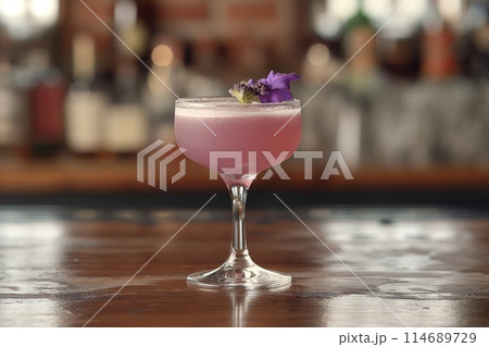 Elegant purple Aviation cocktail in a glass on a bar counter, with a warm, blurred background 114689729