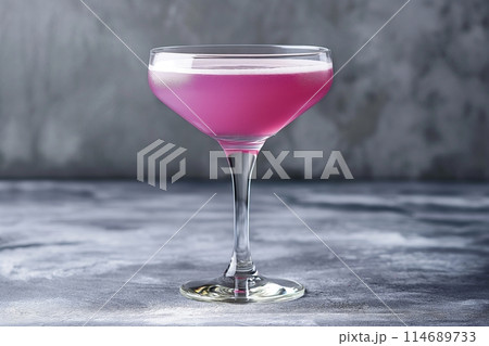 Elegant Aviation cocktail in a classic coupe glass on a textured grey background 114689733