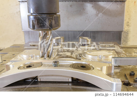 The CNC milling machine cutting aluminum automotive part by rough cutter. The CNC milling machine cutting aluminum automotive part by rough cutter. 114694644