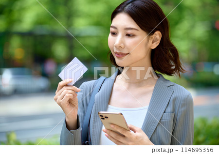 スマホとカードを持つ若いビジネスウーマン スマホとカードを持つ若いビジネスウーマン 114695356