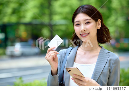 スマホとカードを持つ若いビジネスウーマン 114695357