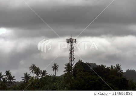 wireless data station against the background of a cloudy sky on a mountain in the jungle. Cell tower wireless data station against the background of a cloudy sky on a mountain in the jungle. Cell tower 114695859