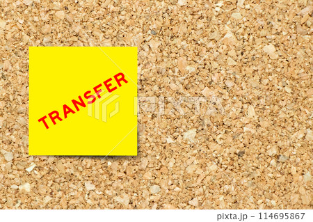 Yellow note paper with word transfer on cork board background with copy space 114695867