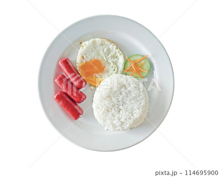 Breakfast on a white plate including sausages, rice, fried egg, fresh vegetables isolated on peach background 114695900