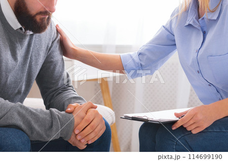 Professional psychologist comforting sad depressed male patient at personal consultation in office Professional psychologist comforting sad depressed male patient at personal consultation in office 114699190