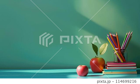 Back to school concept with books, colored pencils and apple on table against green background with copy space for text or as a mockup template. 114699216