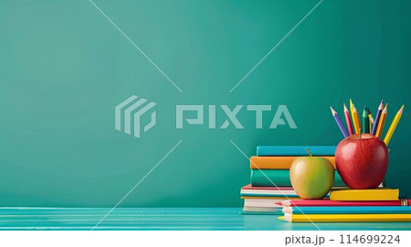 Back to school concept with books, colored pencils and apple on table against green background with copy space for text or as a mockup template. 114699224