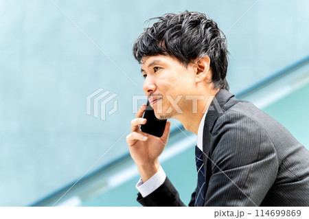 スマホで通話をする男性ビジネスマン スマホで通話をする男性ビジネスマン 114699869