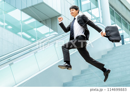 階段を駆け降りる男性ビジネスマン 114699883