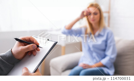 Depressed woman talking to psychotherapist, doctor taking notes about patient's health status, free space Depressed woman talking to psychotherapist, doctor taking notes about patient's health status, free space 114700031