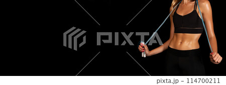 Unrecognizable Lady Holding Jump Rope On Black Studio Background. Fitness Lifestyle Concept. Free Space, Cropped Unrecognizable Lady Holding Jump Rope On Black Studio Background. Fitness Lifestyle Concept. Free Space, Cropped 114700211