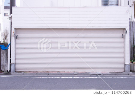 A closeup shot of automatic metal roller door used in factory, storage, garage, and industrial warehouse. The corrugated and foldable metal sheet offer space saving and provide urban and rustic feel A closeup shot of automatic metal roller door used in factory, storage, garage, and industrial warehouse. The corrugated and foldable metal sheet offer space saving and provide urban and rustic feel 114700268
