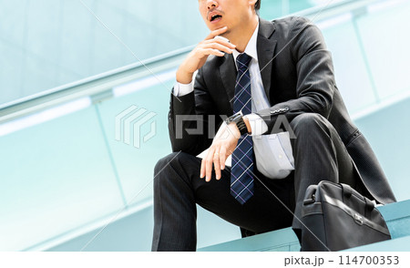考えごとをする男性ビジネスマン 考えごとをする男性ビジネスマン 114700353