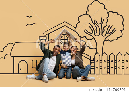 Happy African American family sitting on the ground are gathered in front of a detailed drawing of a house. They appear engaged in conversation or observation of the artwork. 114700701