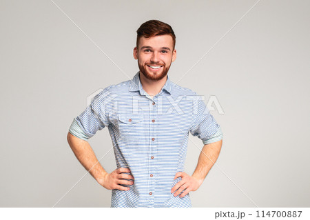 Portrait of smiling guy with hands on hips on beige background, panorama, copy space 114700887
