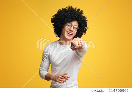 Gotcha. Smiling african american millennial guy indicating you, pointing at camera on orange background 114700965