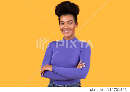 Hispanic woman standing with her arms crossed, smiling warmly. She exudes confidence and contentment as she gazes directly at the camera. Hispanic woman standing with her arms crossed, smiling warmly. She exudes confidence and contentment as she gazes directly at the camera. 114701843