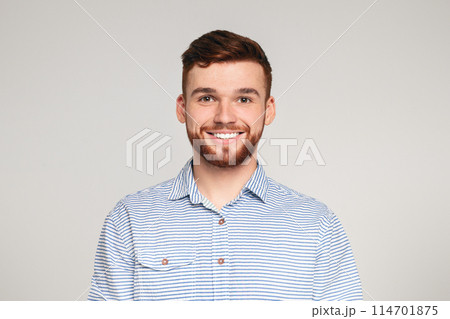 Portrait of smiling millenial guy on beige background, panorama, copy space 114701875