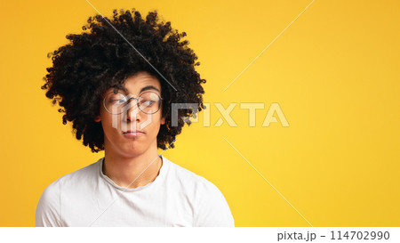 Skeptical young man, funny, suspicious annoyed looking aside at free space on orange background. On his own mind Skeptical young man, funny, suspicious annoyed looking aside at free space on orange background. On his own mind 114702990