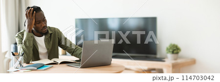 Thoughtful black man using laptop computer working online and thinking about business, touching head, sitting at home office. Entrepreneurship issues concept, panorama with copy space Thoughtful black man using laptop computer working online and thinking about business, touching head, sitting at home office. Entrepreneurship issues concept, panorama with copy space 114703042