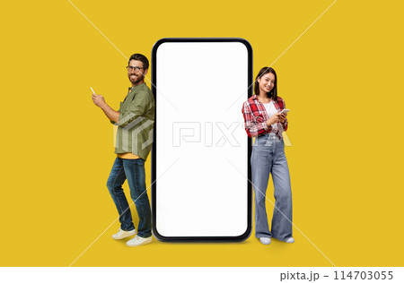 A man and woman Multiracial couple with a big blank smartphone screen for marketers on colorful studio background A man and woman Multiracial couple with a big blank smartphone screen for marketers on colorful studio background 114703055